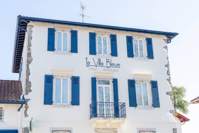 Façade de l’hôtel-restaurant La Villa Bleue à Cambo-les-Bains, maison basque aux volets bleus